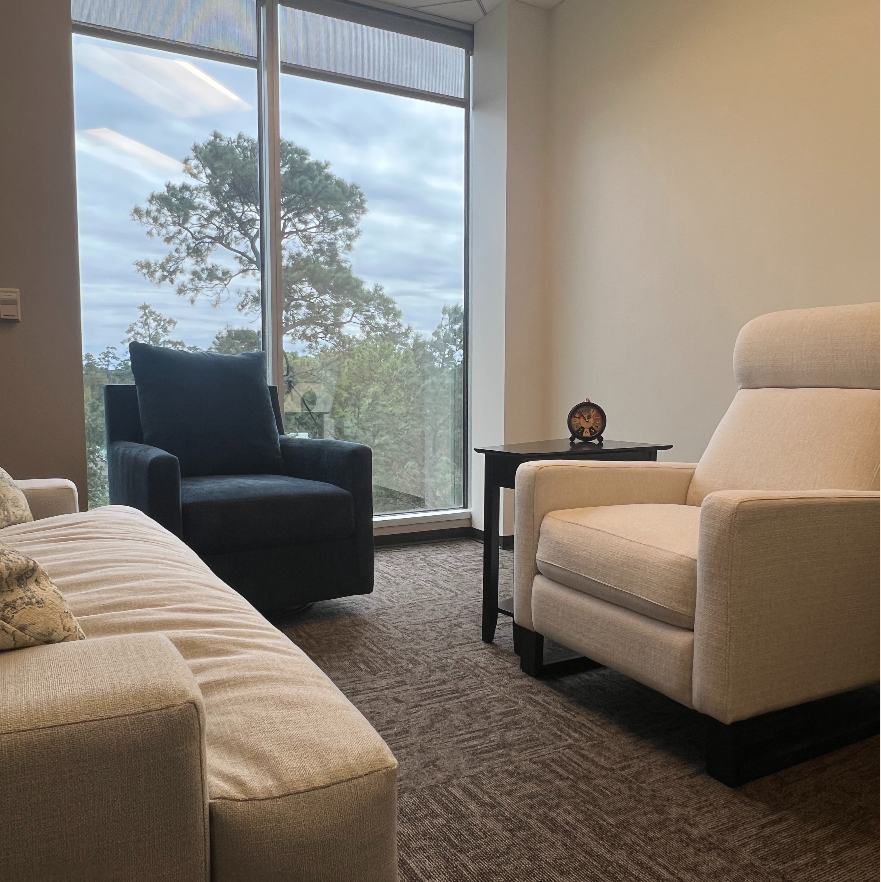 A cozy living room featuring a comfortable couch and a stylish chair, creating an inviting atmosphere for relaxation.